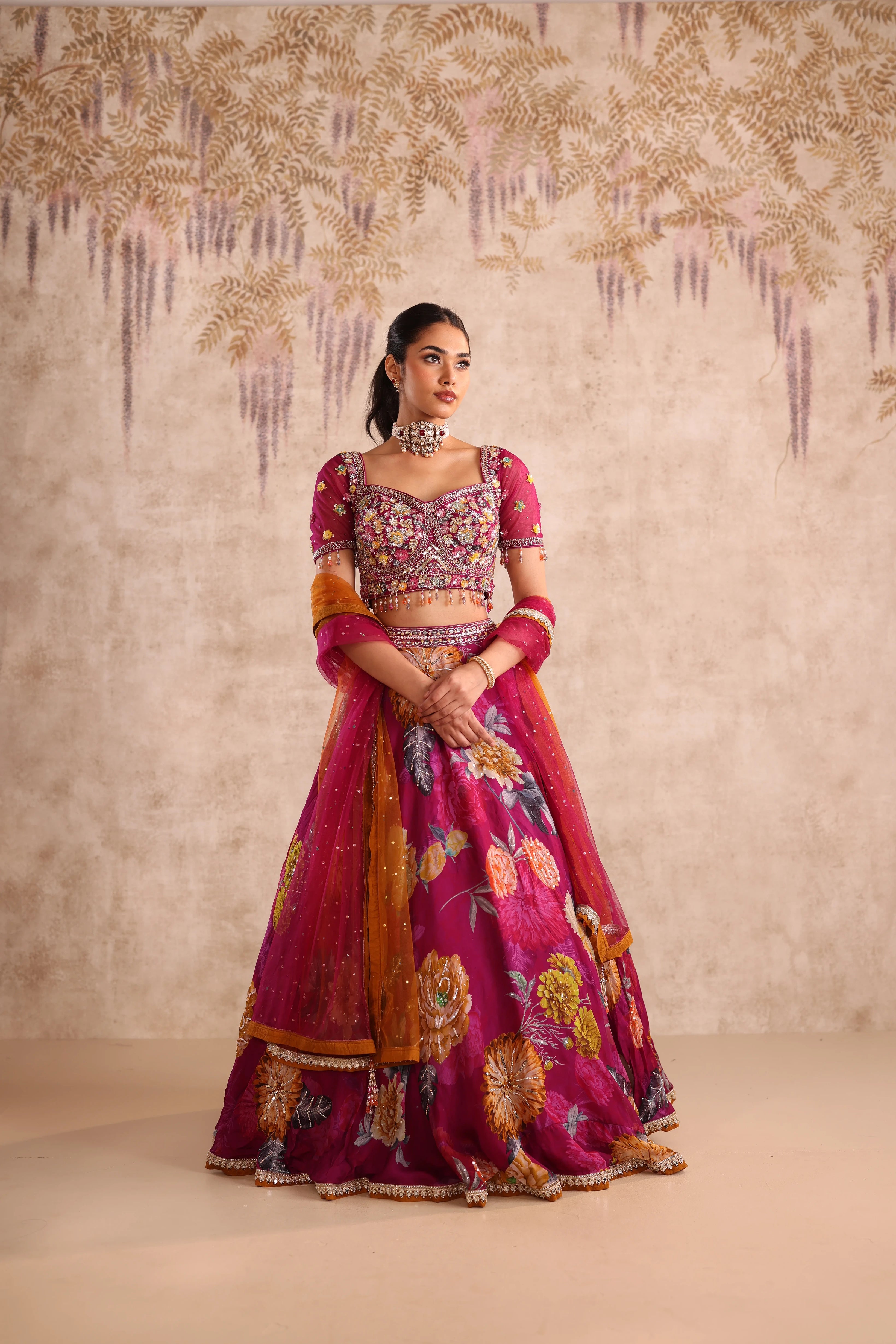 Woman in a traditional embroidered outfit with a decorative background