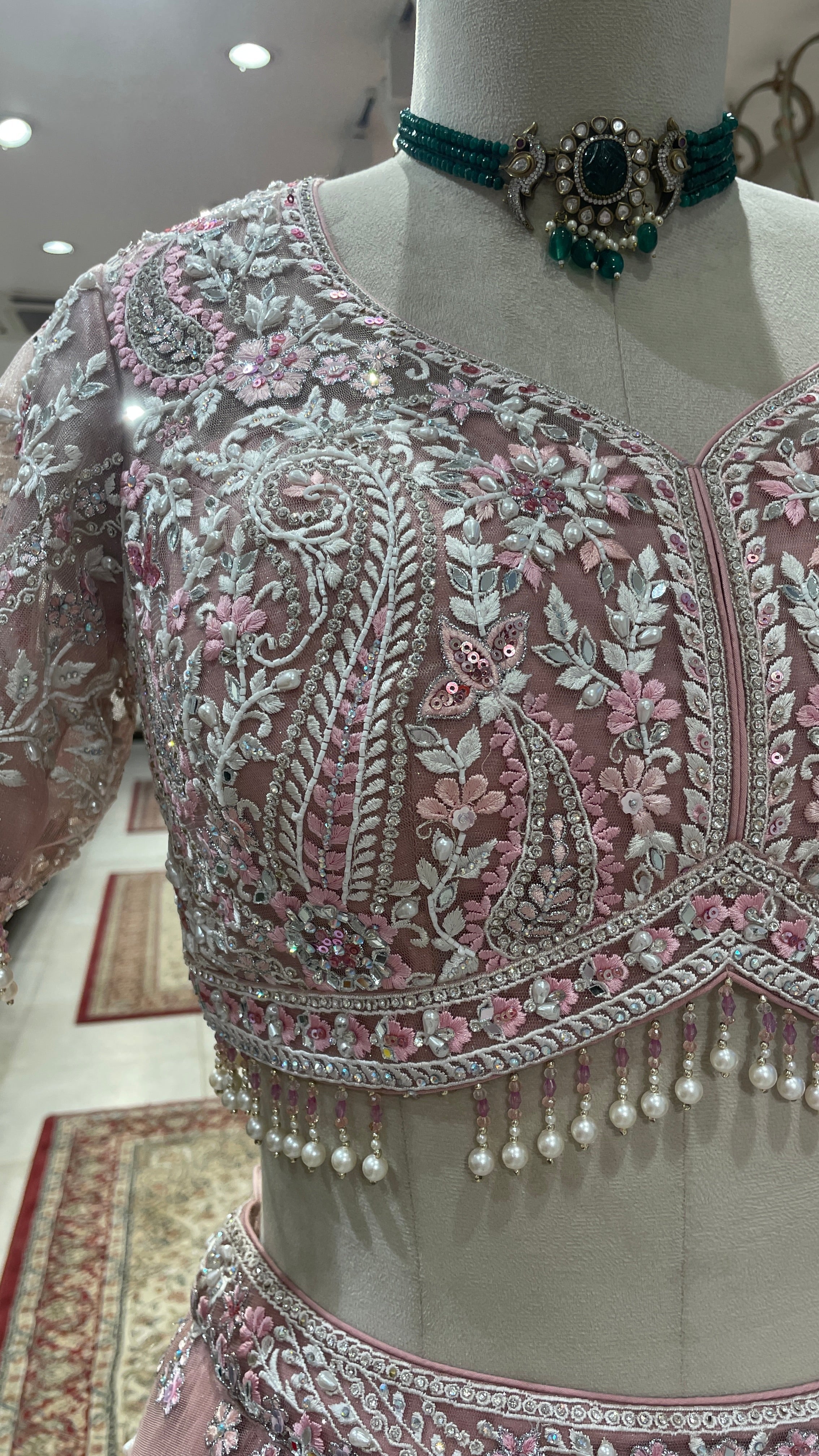 Pink net lehenga with mirrorwork and floral motifs