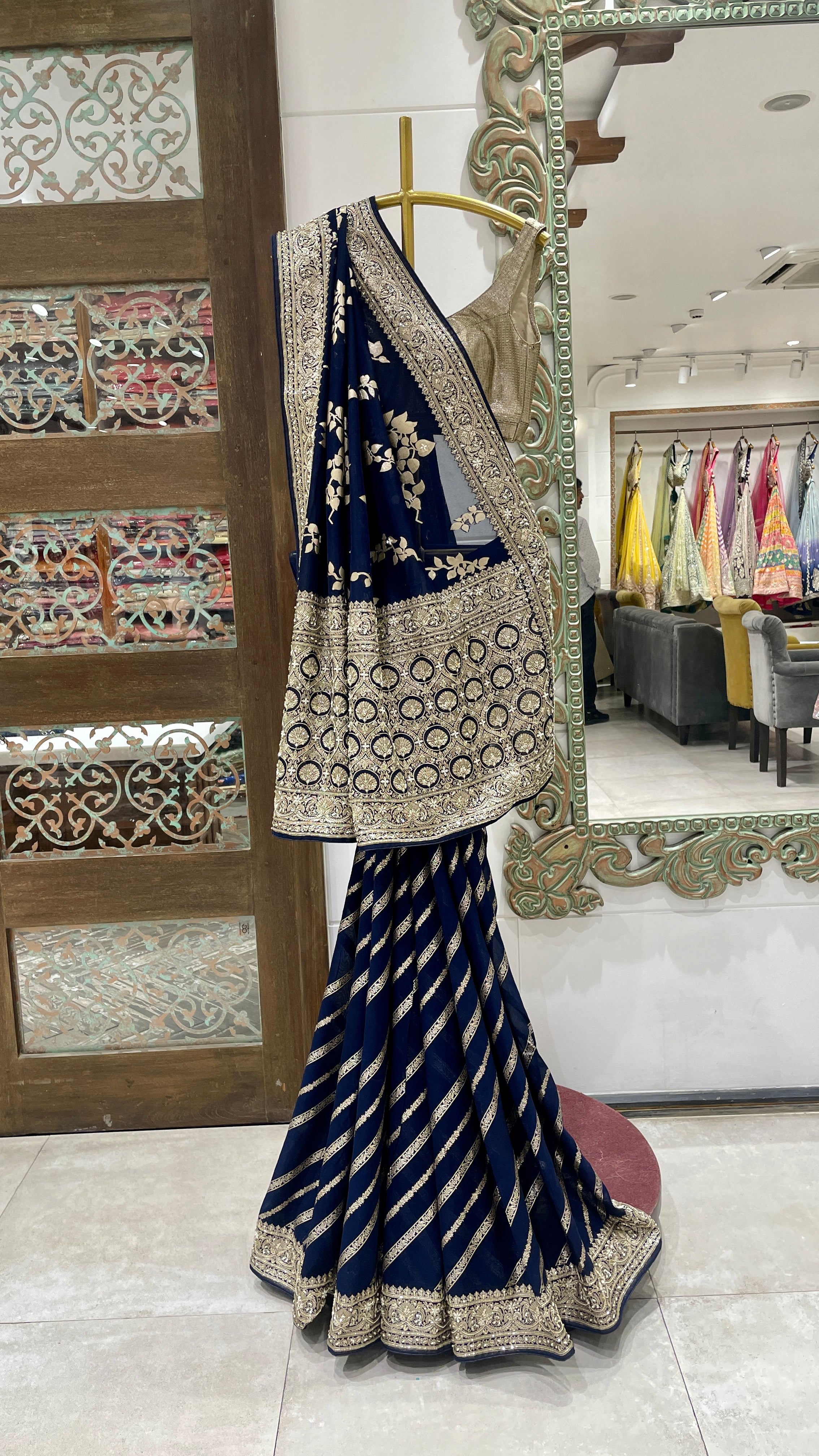 A blue georgette Banarasi khadri saree draped over a mannequin, displaying intricate khadri work and a floral design.