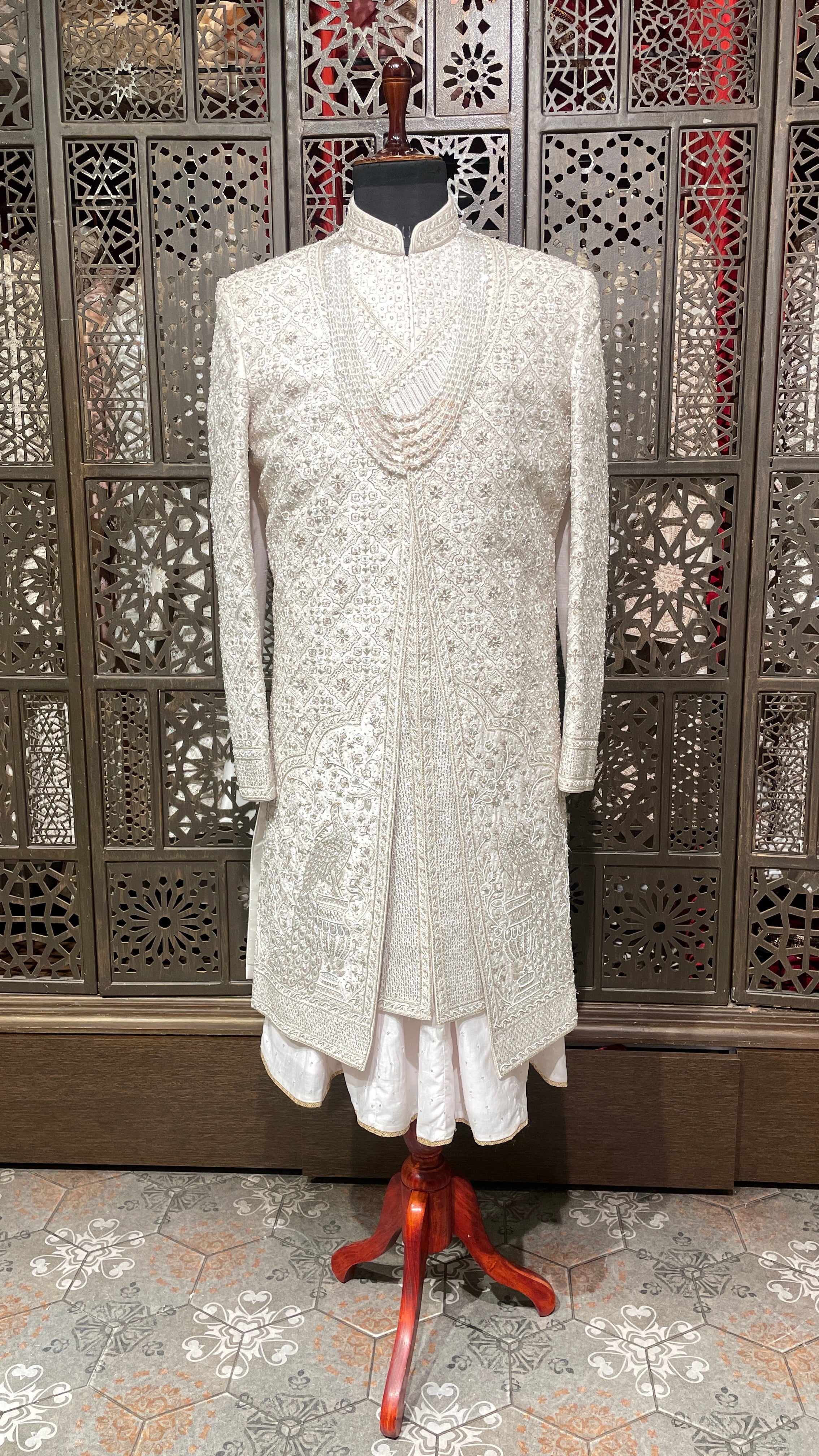 Cream layered sherwani with peacock motifs and zariwork