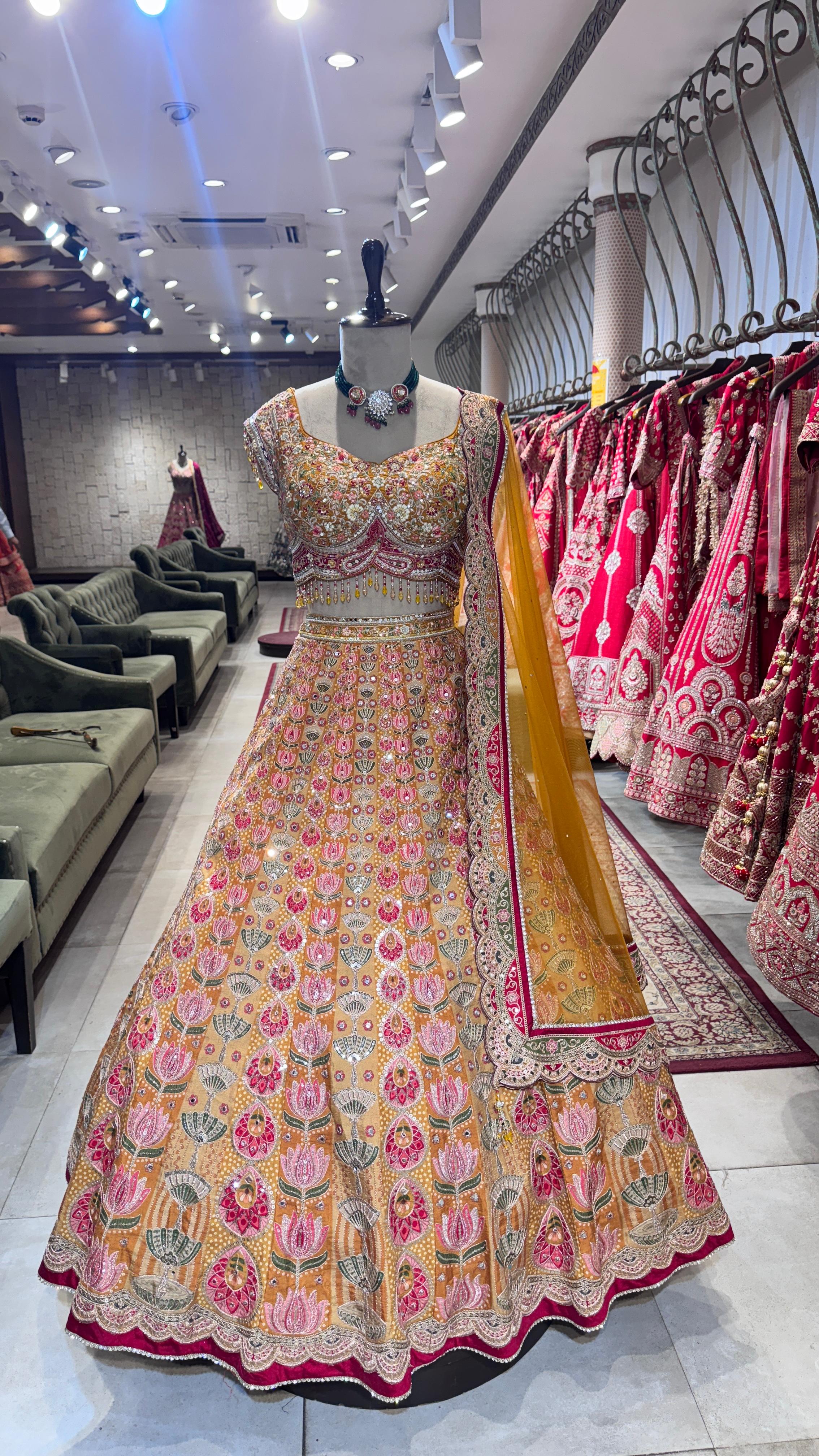 Traditional embroidered dress on a mannequin in a store setting with other dresses in the background.