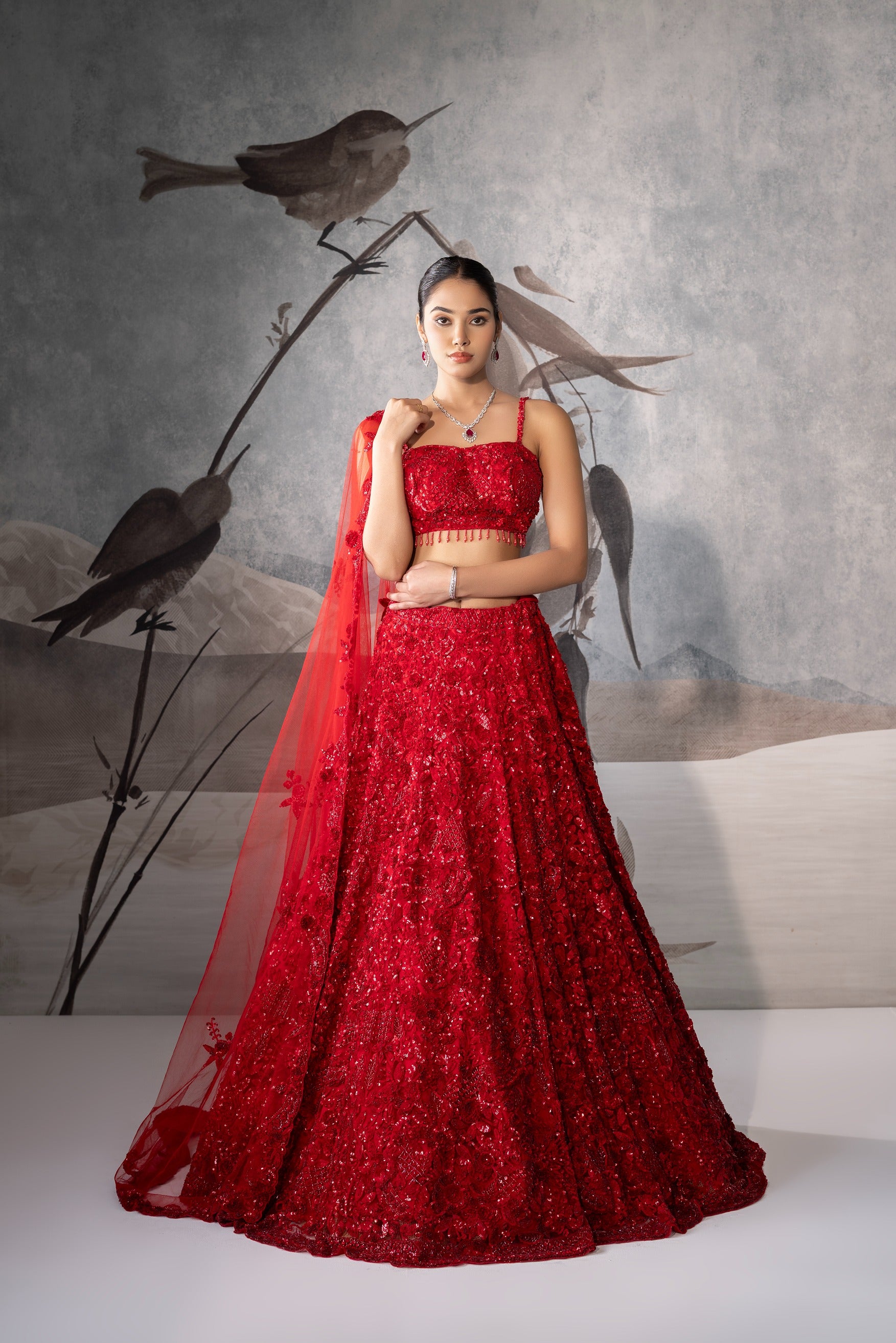 Woman in a red traditional outfit with birds in the background