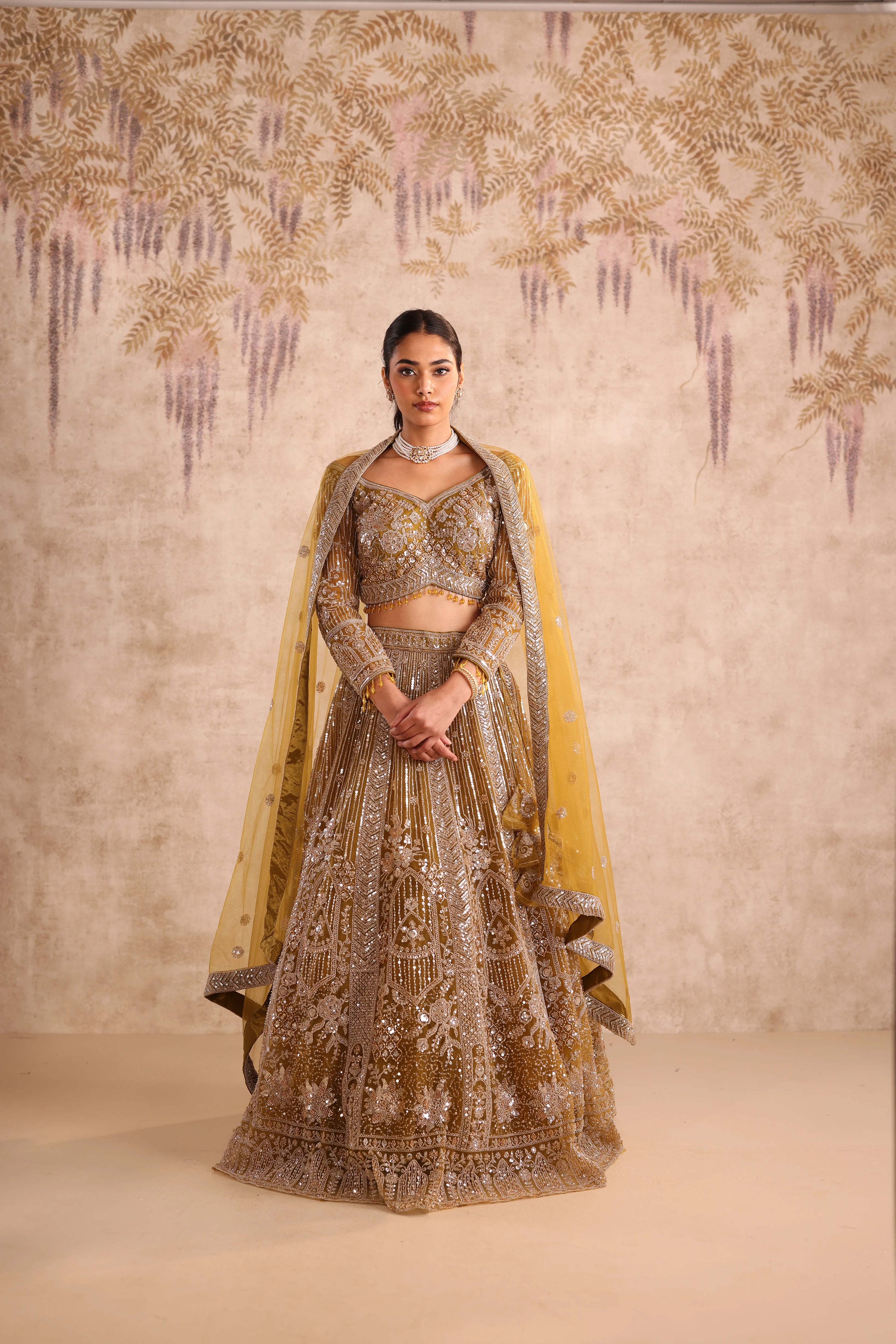 Woman in a traditional embroidered outfit with a decorative background
