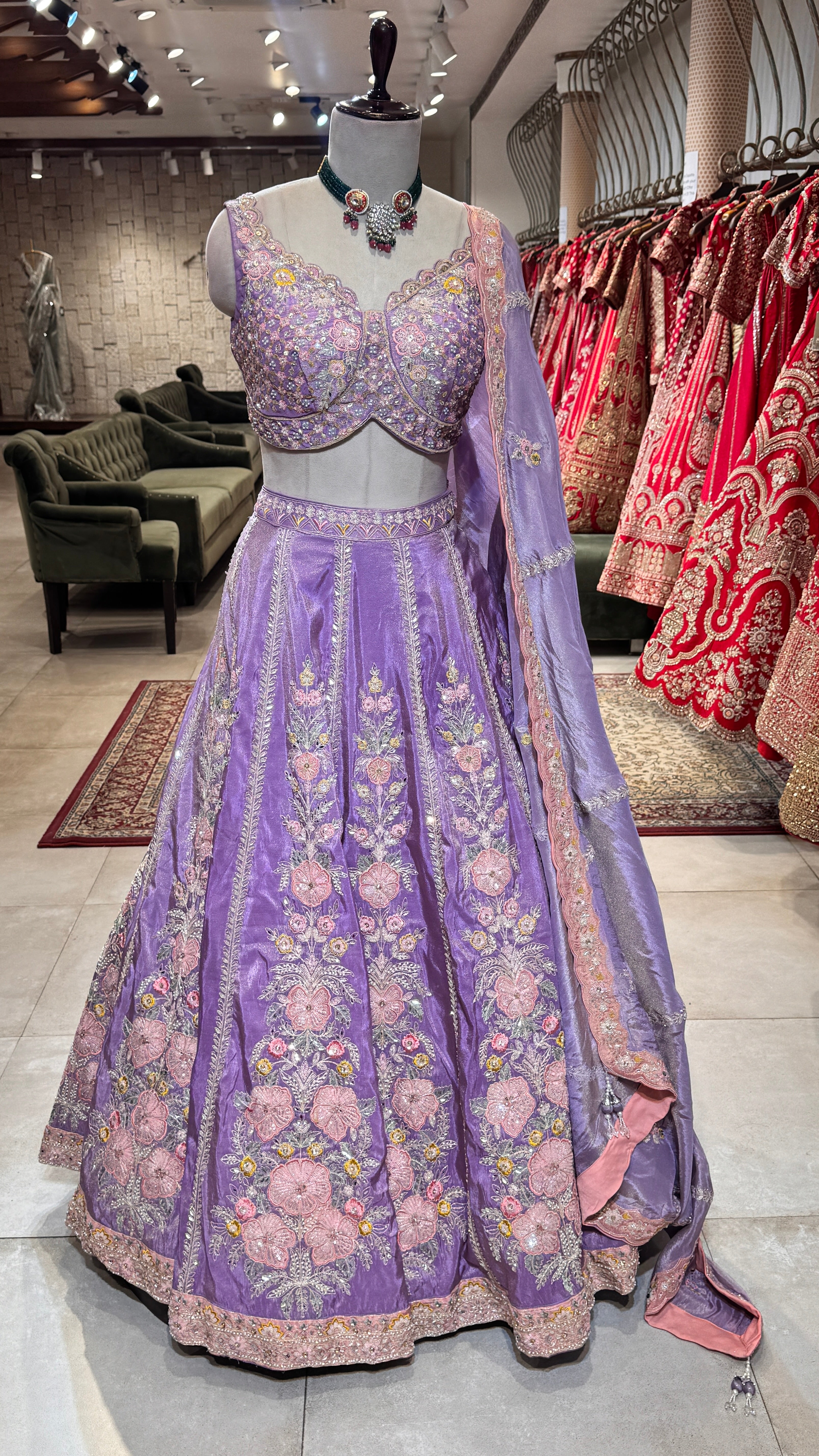 A lavender floral lehenga with a matching blouse and a sheer dupatta, displayed on a mannequin.