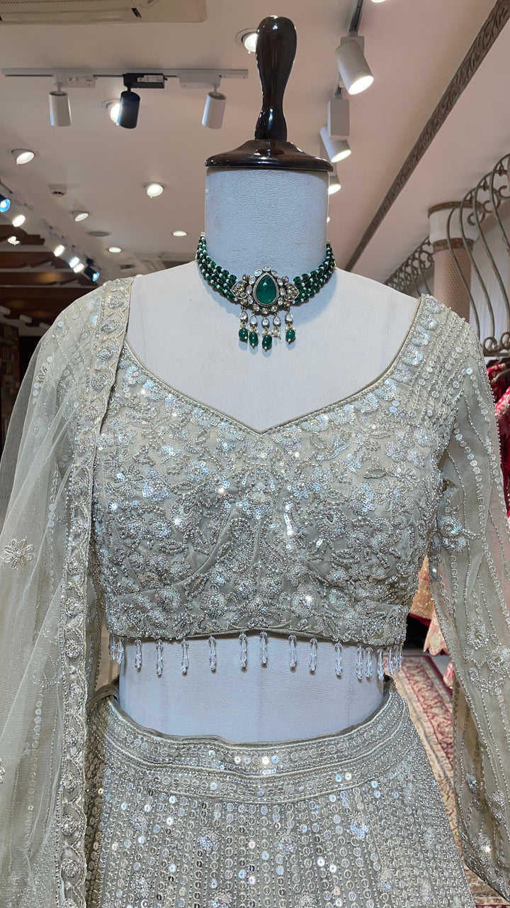 Cream net lehenga with cutdana and floral motifs