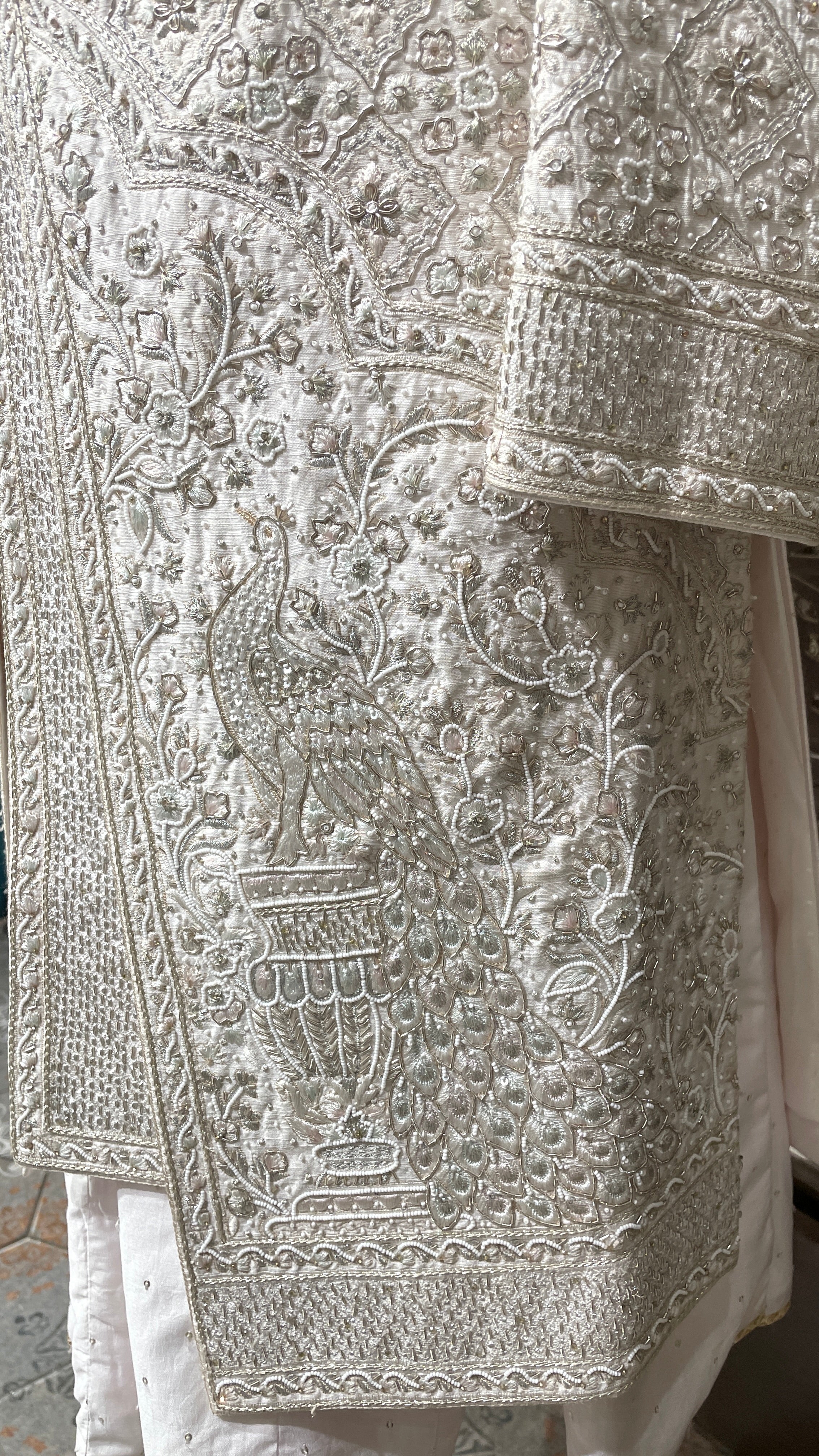 Cream layered sherwani with peacock motifs and zariwork