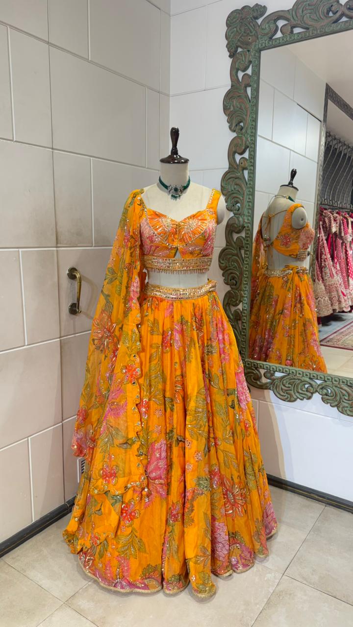 Yellow floral dress on a mannequin with a mirror reflection in a room.