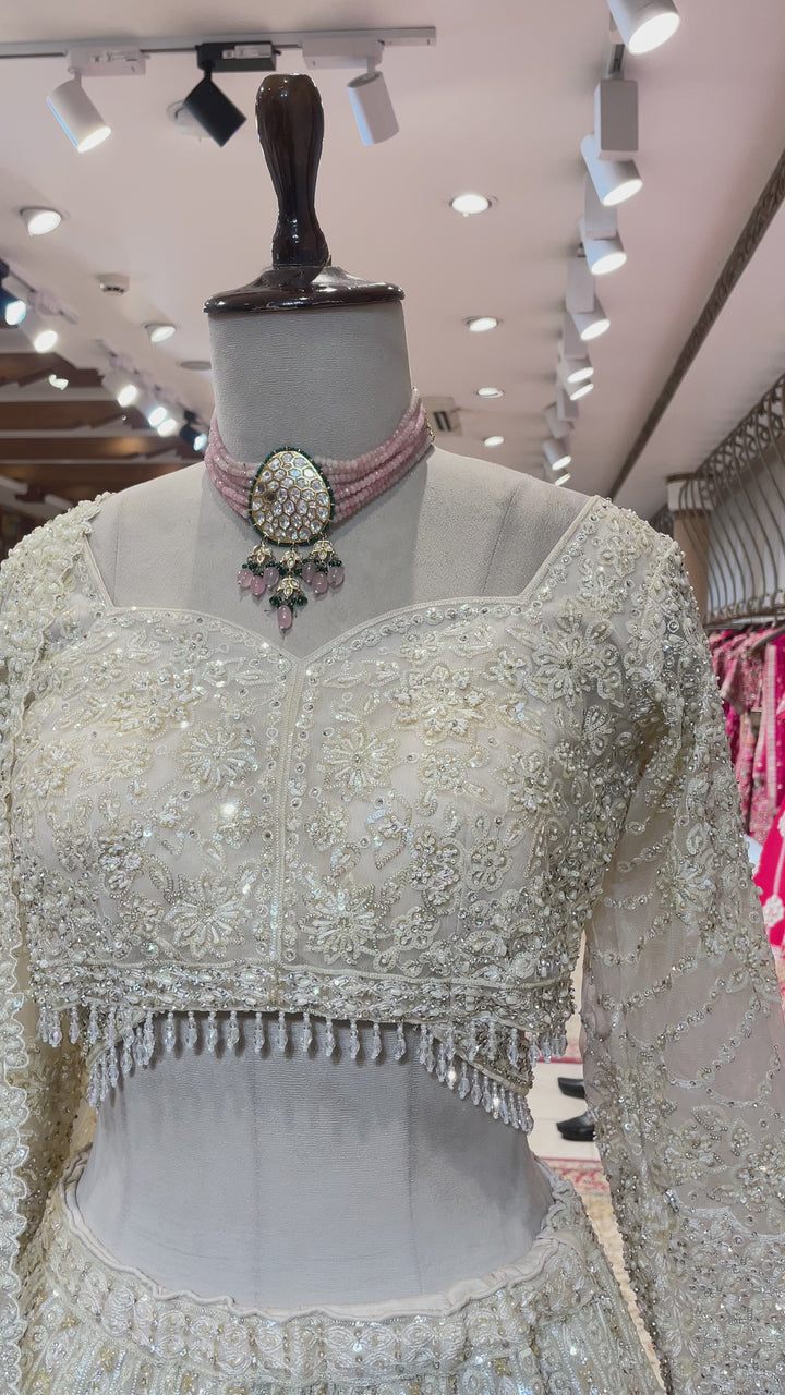 Ivory net lehenga with pearl and sequins embellishments